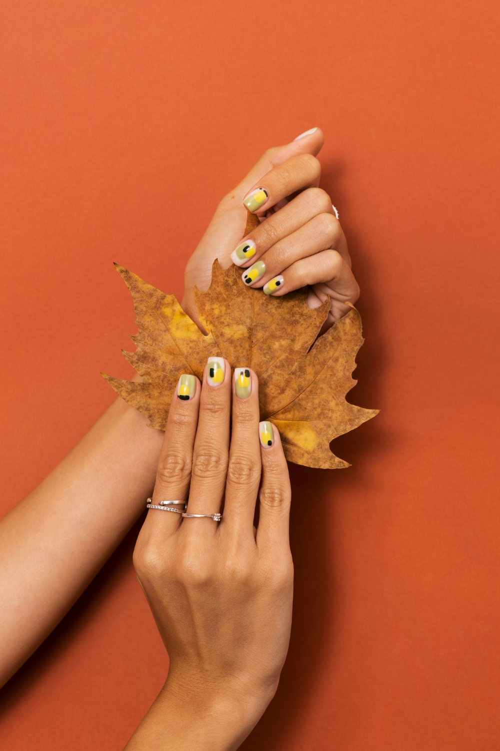 woman-showing-her-nail-art-fingernails-with-autumn-leaf